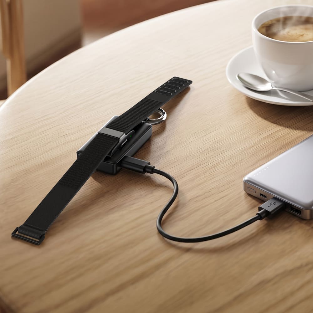 Hume Band 1.0 charger connected to power bank on coffee table with SwanScout 513